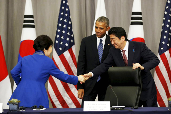 President Barack Obama watched as South Korean President Park Geun-hye, left, and Japanese Prime Minister Shinzo Abe shook hands at the Nuclear Security Summit on Thursday, March 31, 2016. (Photo: kevin lamarque/Reuters) 
